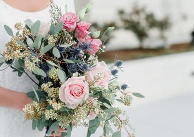 Bridal bouquet that includes blush pink roses, thistle, and seeded eucalyptus.